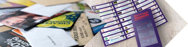Pile of assorted leaflets next to an organised Stevenage PhoneFile business guide
