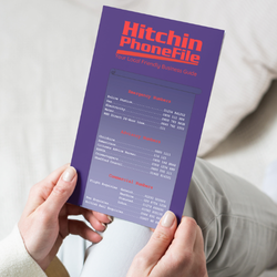 Person holding and reading a Hitchin PhoneFile local business guide